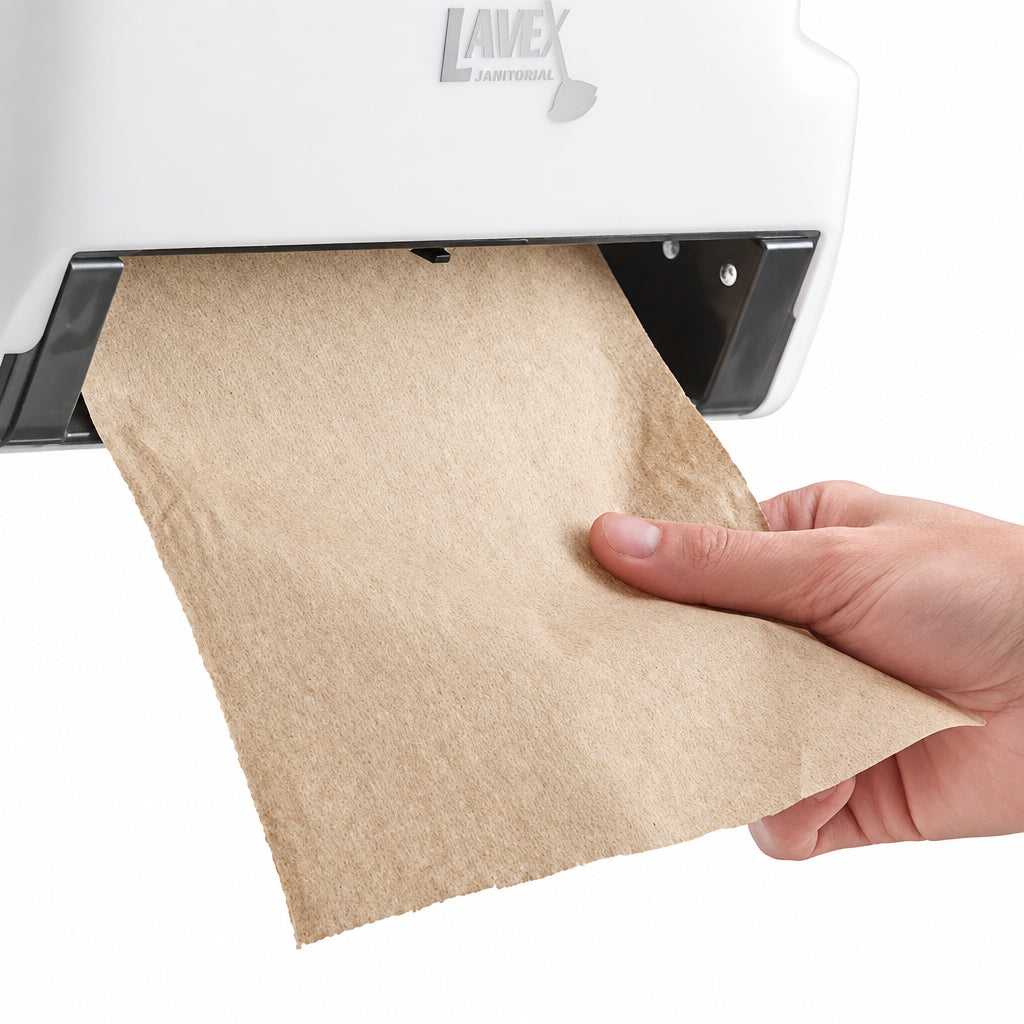 Hand pulling a brown paper towel sheet from a wall dispenser