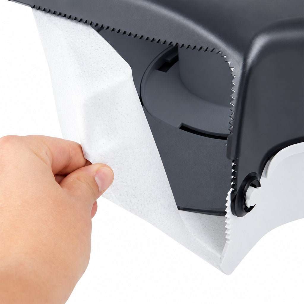Hand tearing tissue at the serrated edge inside a jumbo roll dispenser