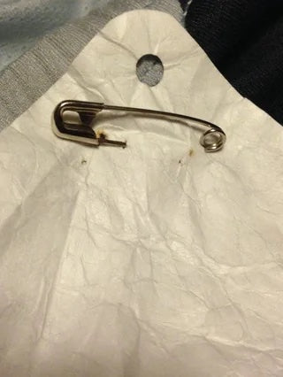 A #1 safety pin securely fastening a number to a shirt, ready for the race.